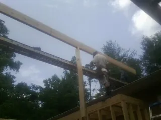 Carpenter setting a ridge beam over a new addition frame — Ice Dam Removal by Roofing Brothers in Reidville