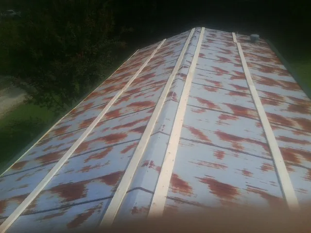 Rusted metal roof panels with new wood purlins before replacement — Storm Damage Roof Repair in Reidville by Roofing Brothers