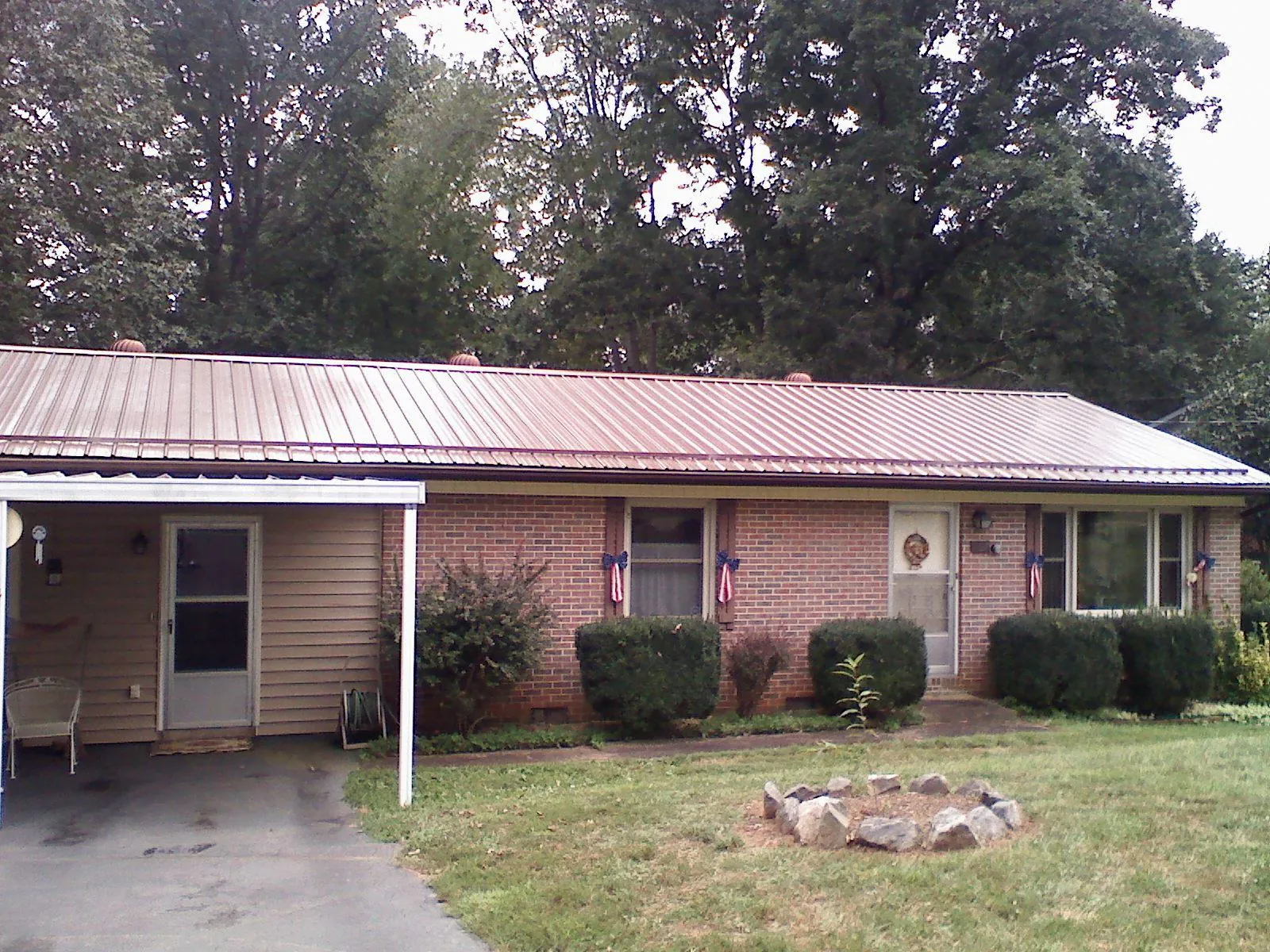 Bronze metal roof and carport on a brick ranch home — Roof Repair work by our crew in Reidville